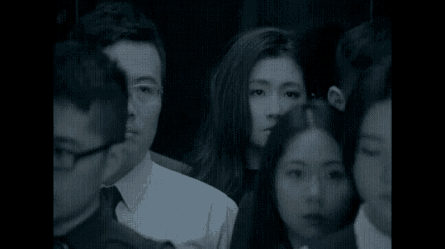 a group of people sitting in a dark room with chinese writing on the bottom