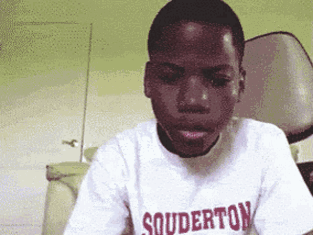 a boy wearing a white shirt that says souderton