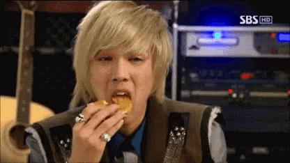 a man eating a sandwich with sbs hd written on the bottom right