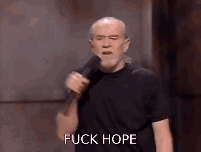 a man with a beard is holding a microphone and saying " fuck hope " .