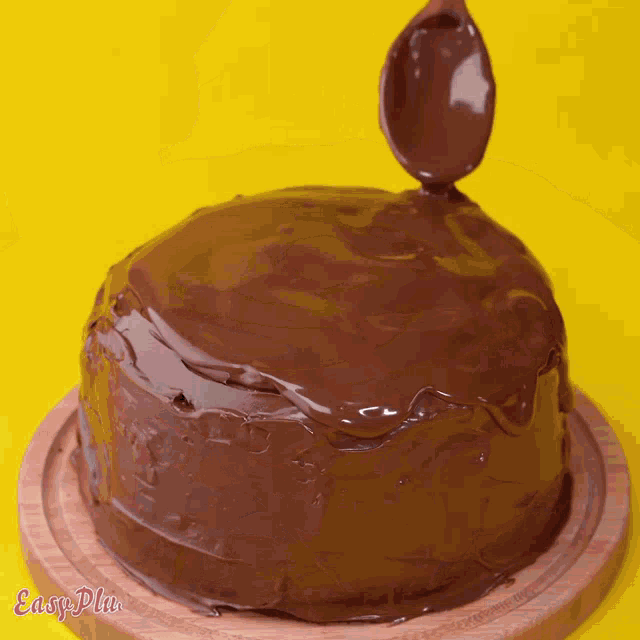 a chocolate cake on a wooden cutting board with easy plus written on the bottom