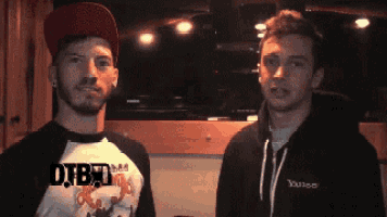 two men are standing next to each other and one has a yahoo sweatshirt on