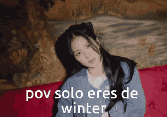 a girl is sitting on a red couch with the words pov solo eres de winter written in white
