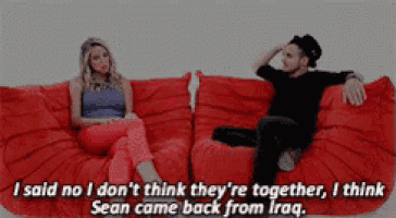 a man and a woman are sitting on a red couch and the man says i said no i don t think