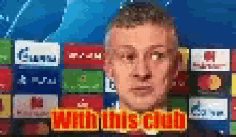 a man is standing in front of a sign that says with this club