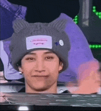 a close up of a person wearing a knitted hat with cat ears .