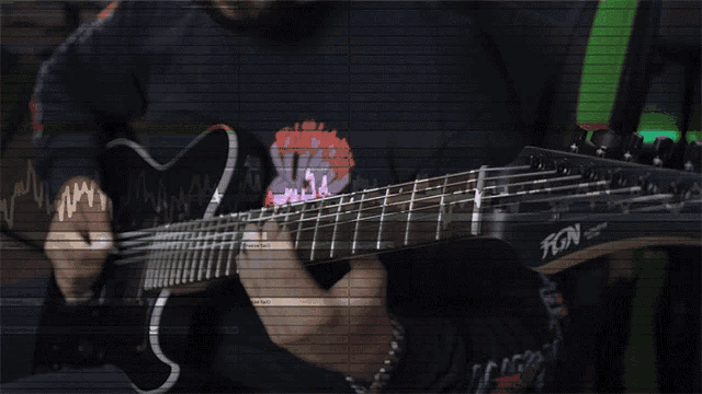 a man is playing a guitar with fgn on the neck