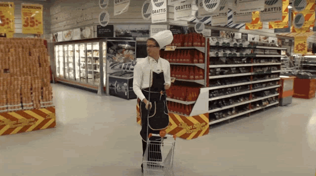 a man in a chef 's hat pushes a shopping cart in a store