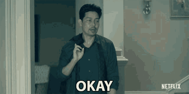 a man walking down a hallway with the word okay written on his chest