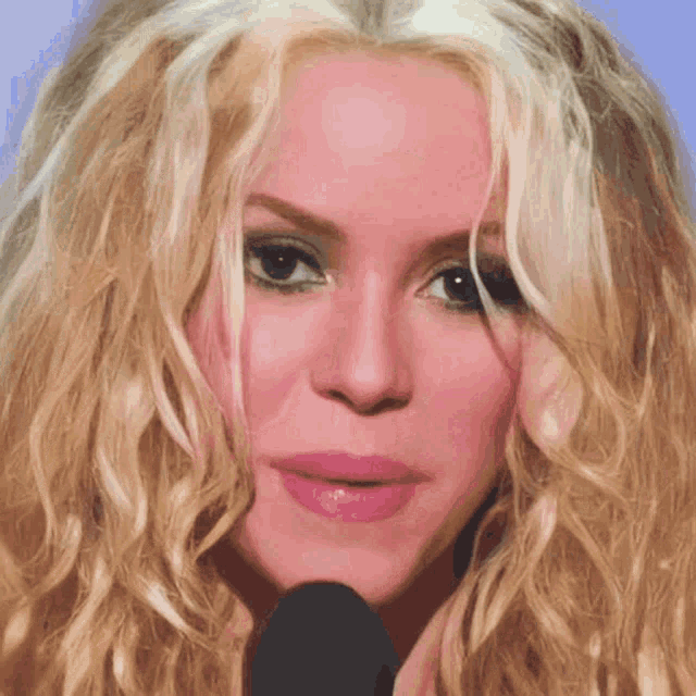 a close up of a woman 's face with long blonde hair