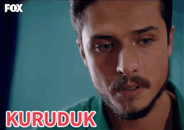 a close up of a man 's face with the word kuruduk in white