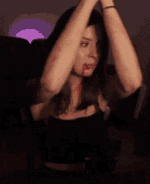 a woman with blood on her face is wearing headphones and a black top