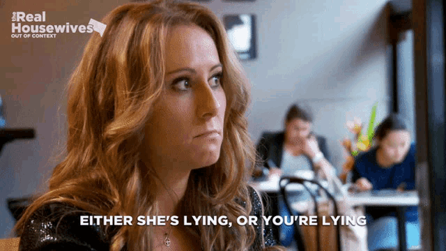 a woman sitting at a table with either she 's lying or you 're lying