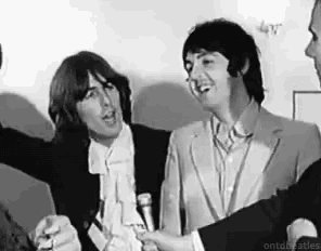 two men are standing next to each other in a black and white photo .