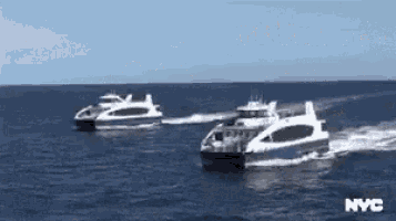 two boats are floating in the ocean on a sunny day .