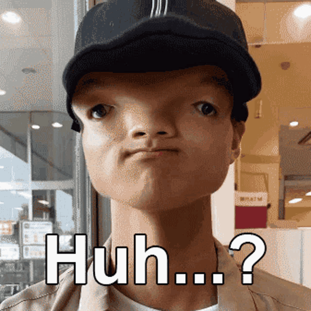 a man wearing a baseball cap is making a funny face and has the word huh written on his face