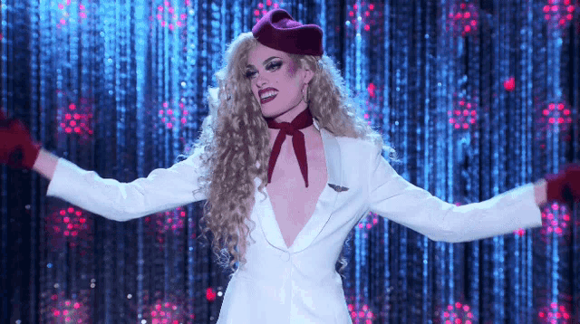a woman in a white jacket and red gloves is dancing on a stage