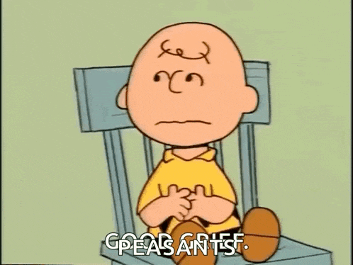 charlie brown is sitting in a chair with a sad face and the words `` greasants '' written on his face .