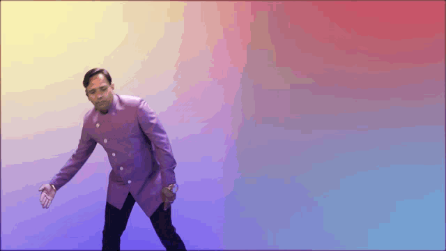 a man in a purple suit stands in front of a colorful background