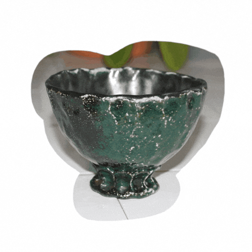 a green and black bowl with a white background