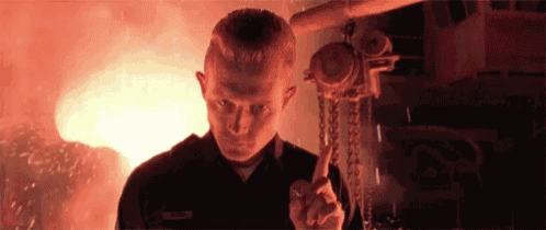 a man in a black uniform is holding a tool in front of a fire