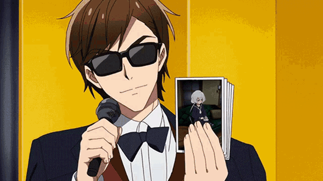 a man in a suit holding a microphone and a picture