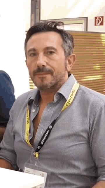 a man with a beard and a lanyard around his neck that says gamescom .