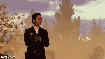 a man in a suit is standing in front of a foggy forest with imgflip.com in the corner