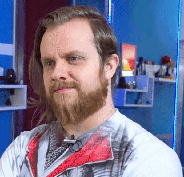 a man with long hair and a beard is wearing a microphone around his neck .