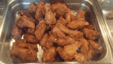 a tray of fried chicken wings sits on a buffet table