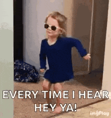 a little girl wearing sunglasses is standing in a doorway and says `` every time i hear hey ya ! ''