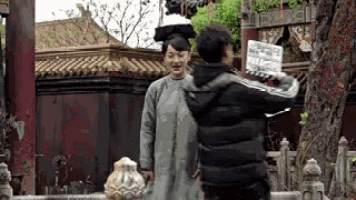 a man is taking a picture of a woman in a gray dress