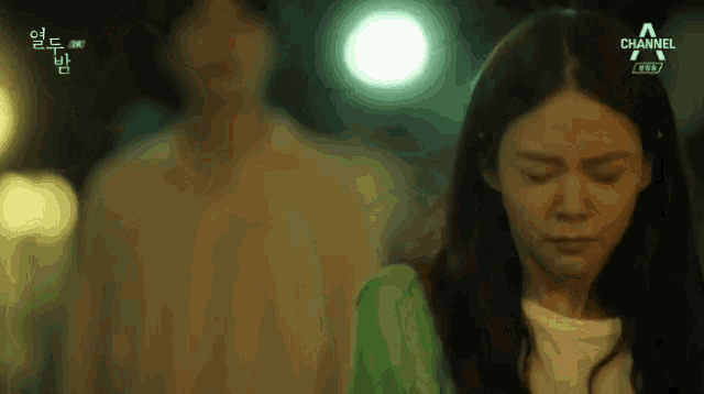a man and a woman are standing next to each other and the woman is wearing a green shirt