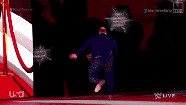 a man in a blue suit is walking on a red carpet .