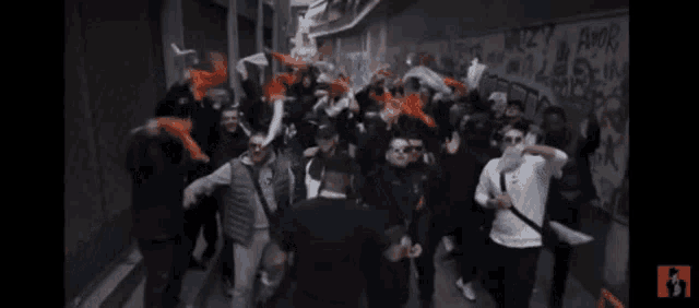 a group of people are dancing in front of a wall that has graffiti on it including the word amor