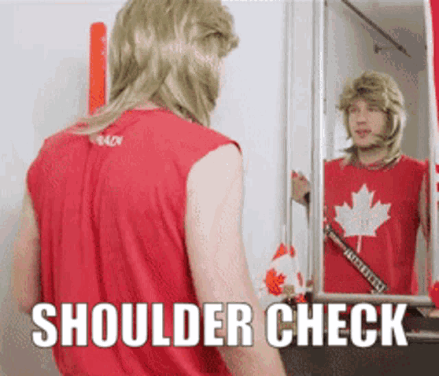 a man wearing a red shirt with a maple leaf on it is looking at his shoulder