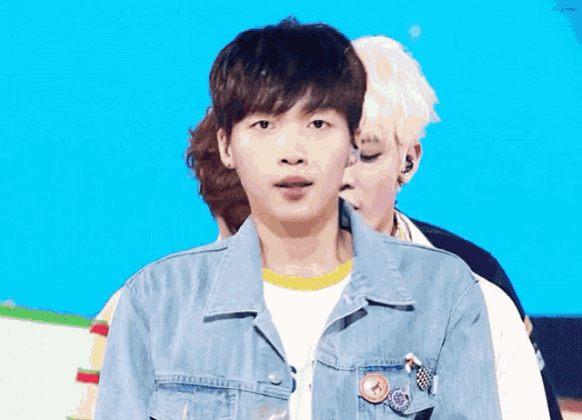 a young man wearing a denim jacket with buttons on it