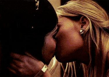 two women kissing with one wearing a bracelet with the letter v