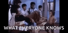 a group of people are sitting in a room with the words `` what everyone knows '' written on the screen .
