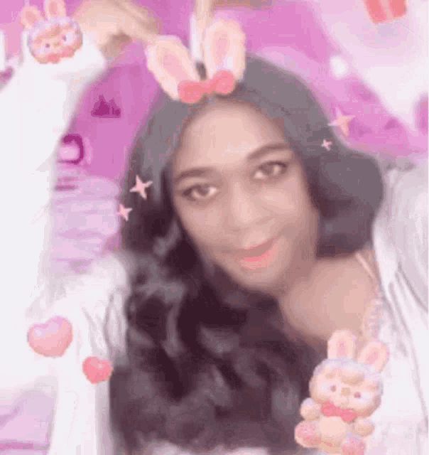 a woman is taking a selfie with bunny ears on her head and holding a stuffed animal .
