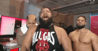 three wrestlers are standing next to each other in a room .