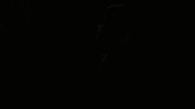 a woman in a white dress and black hat stands in a room with other women