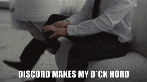 a man in a suit sits on a couch with the words discord makes my d * ck hard above him
