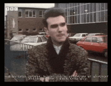 a man is standing in front of a bbc logo