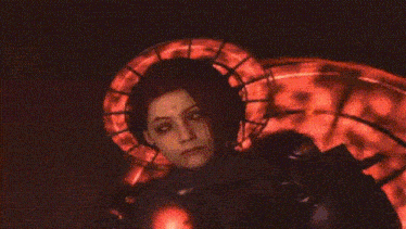 a close up of a person 's face with a red halo around their head .