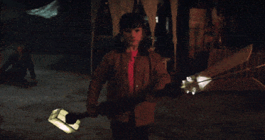 a young boy in a brown jacket holds a large sword