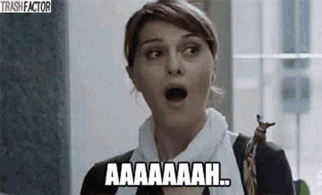 a woman is making a surprised face and saying aa aa aah .
