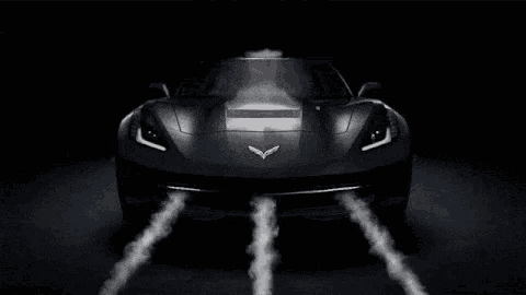 a black sports car with smoke coming out of its exhaust pipes .