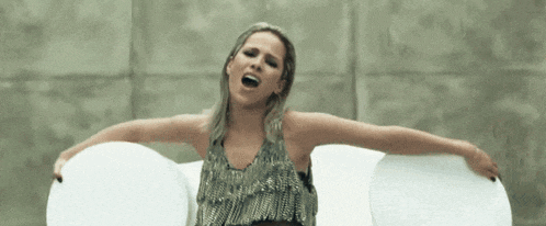 a woman with her arms outstretched is singing