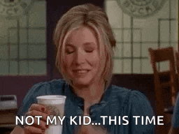 a woman is sitting at a table in a restaurant holding a cup of coffee and saying `` not my kid ... this time '' .